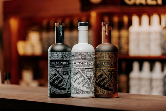 Bottles of Salford Distillery spiced rum on a bar, including Original Golden Spiced and Dark Spiced