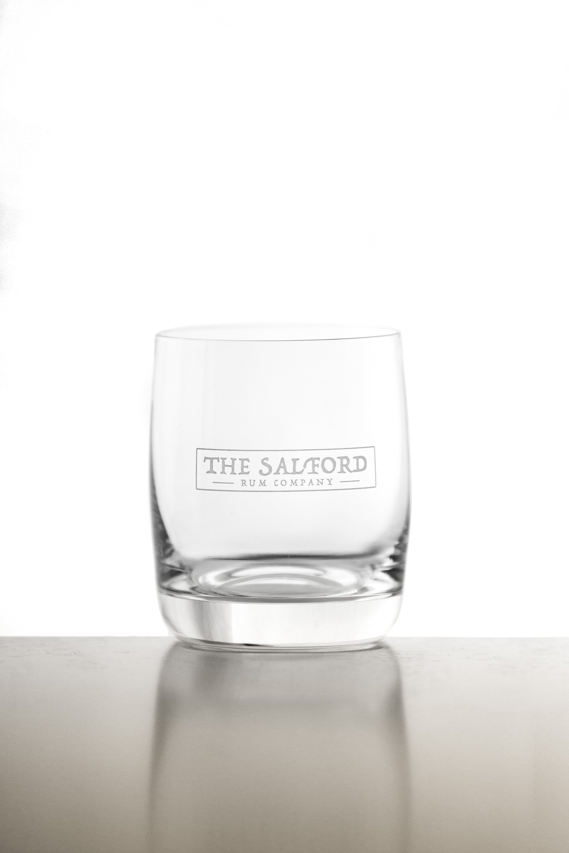 Salford Rum tumbler glass close-up showing etched logo