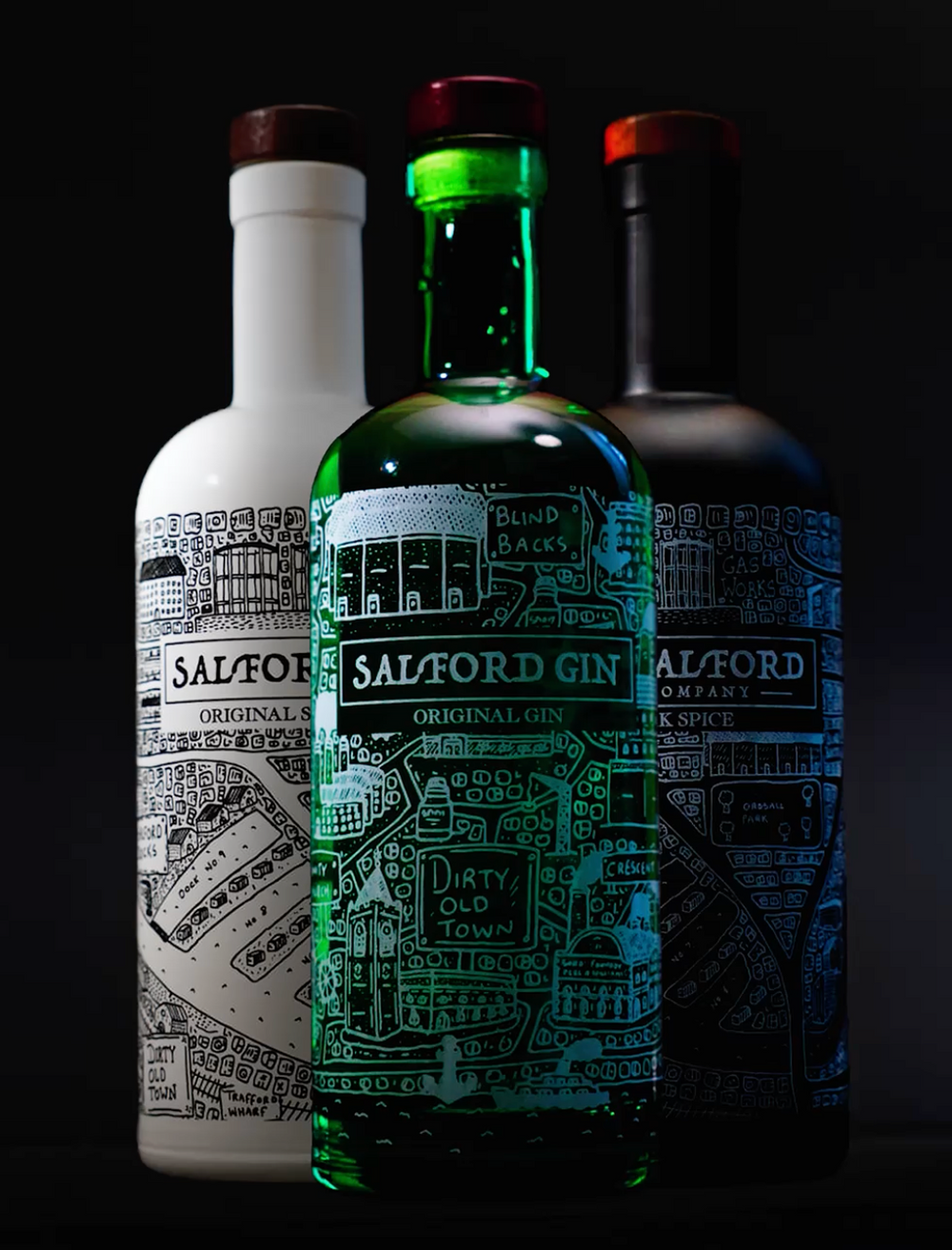 The complete Salford Distillery spirit collection featuring the new Salford Gin bottle alongside the classic Dark Spice and Original Spiced Rum ceramic bottles.